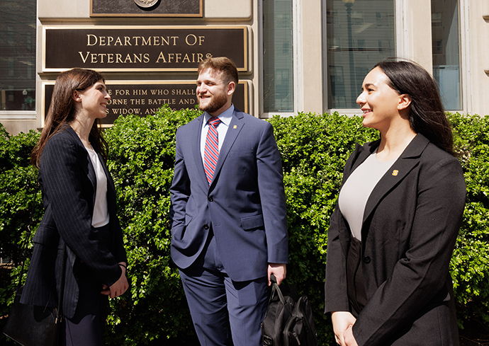 three people standing outside Department of Veterans Affairs building