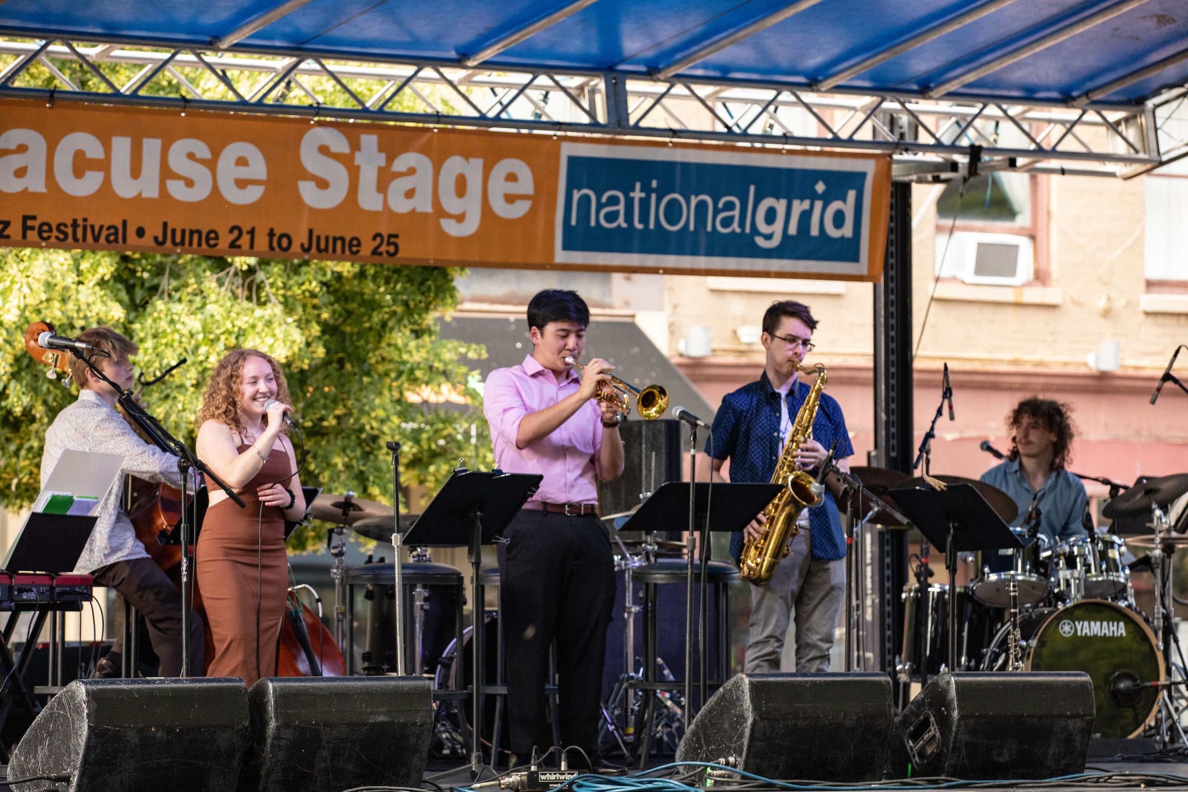 Five individuals on stage performing during Jazz Fest.