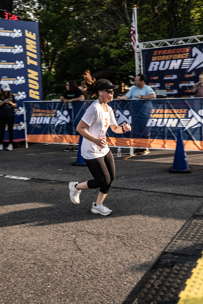 A runner crosses the finish line at the Syracuse WorkForce Run