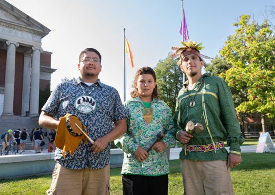 Three Haudenosaunee Welcome Gathering participants pose for a photo on Syracuse University's quad.