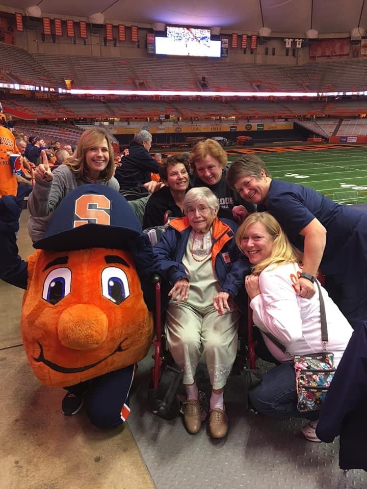 Group of people huddled together with Otto in the Dome during a game. 