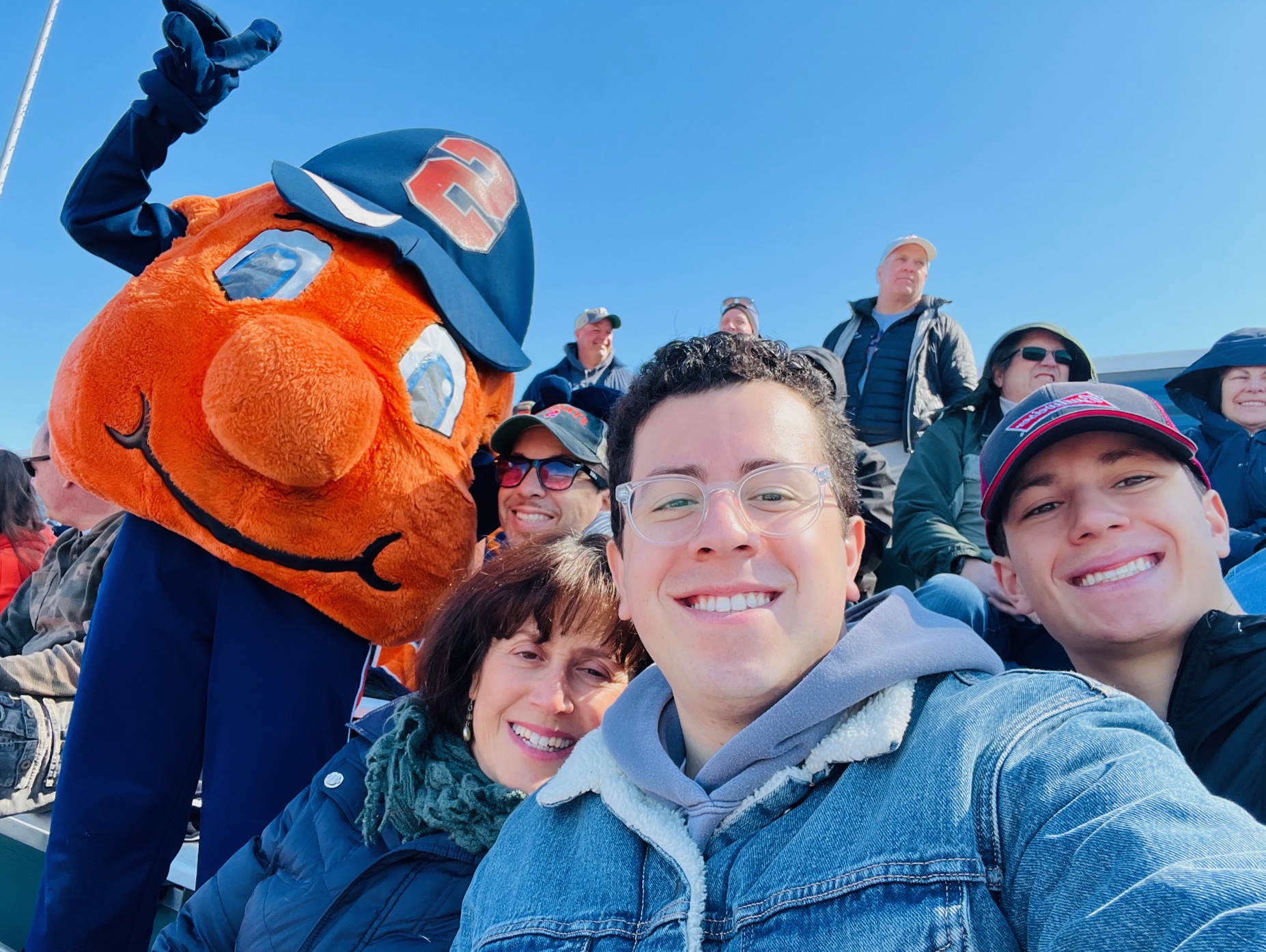 Group of people with Otto at an outdoor womens lacrosse game. 