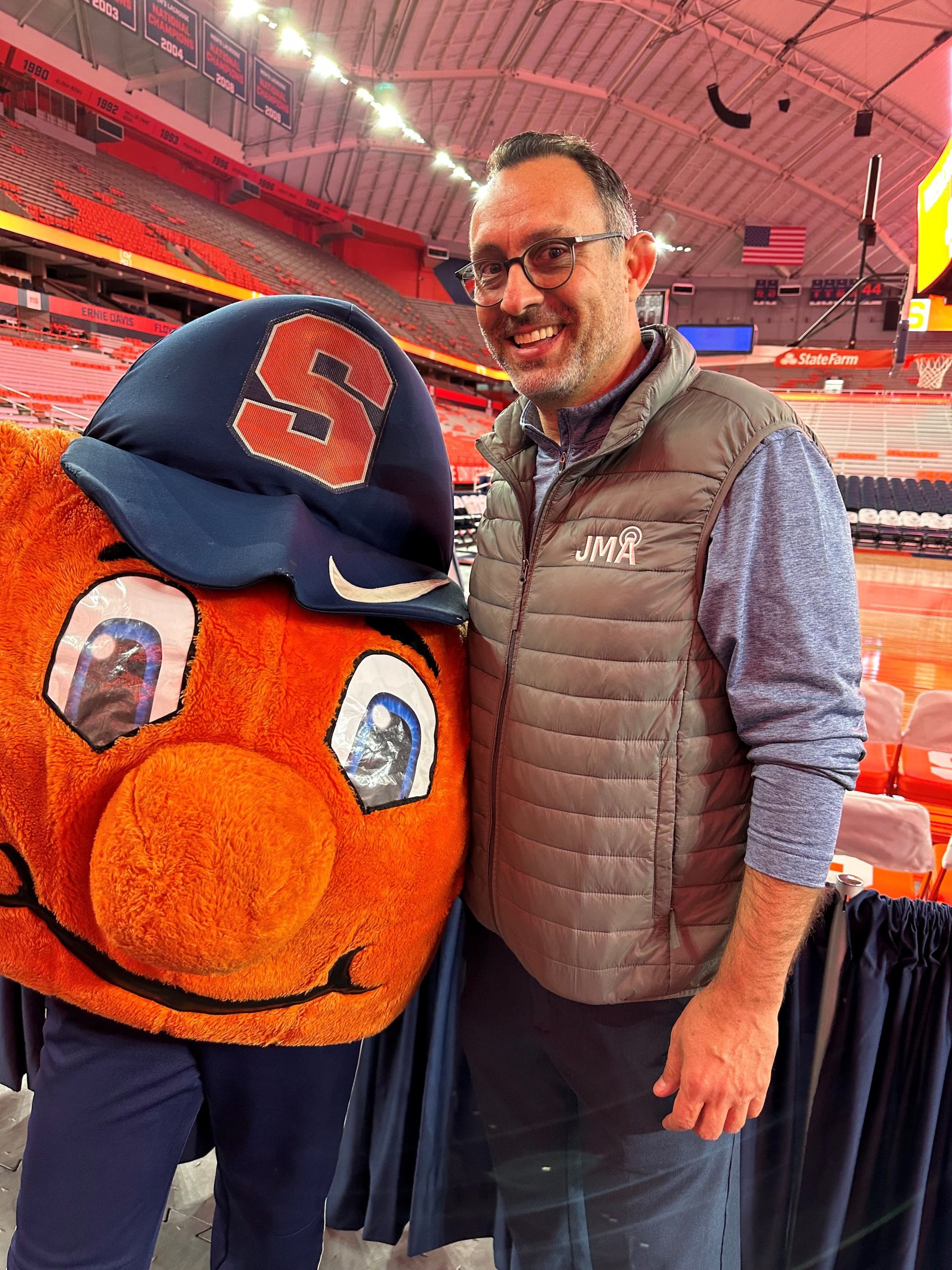 Individual standing with Otto court-side before a basketball game. 