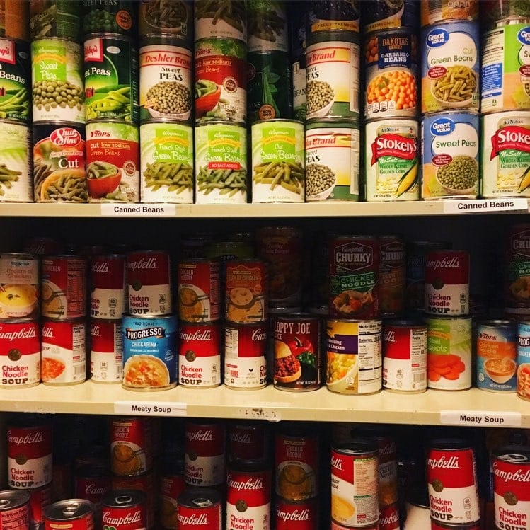 Three shelves full of various canned goods