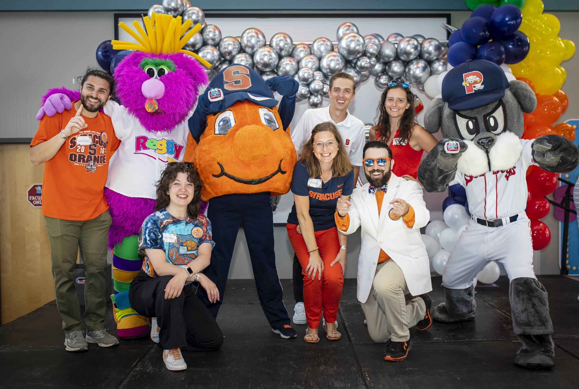 Otto the Orange and Slugger the Seadog with a group of people standing together
