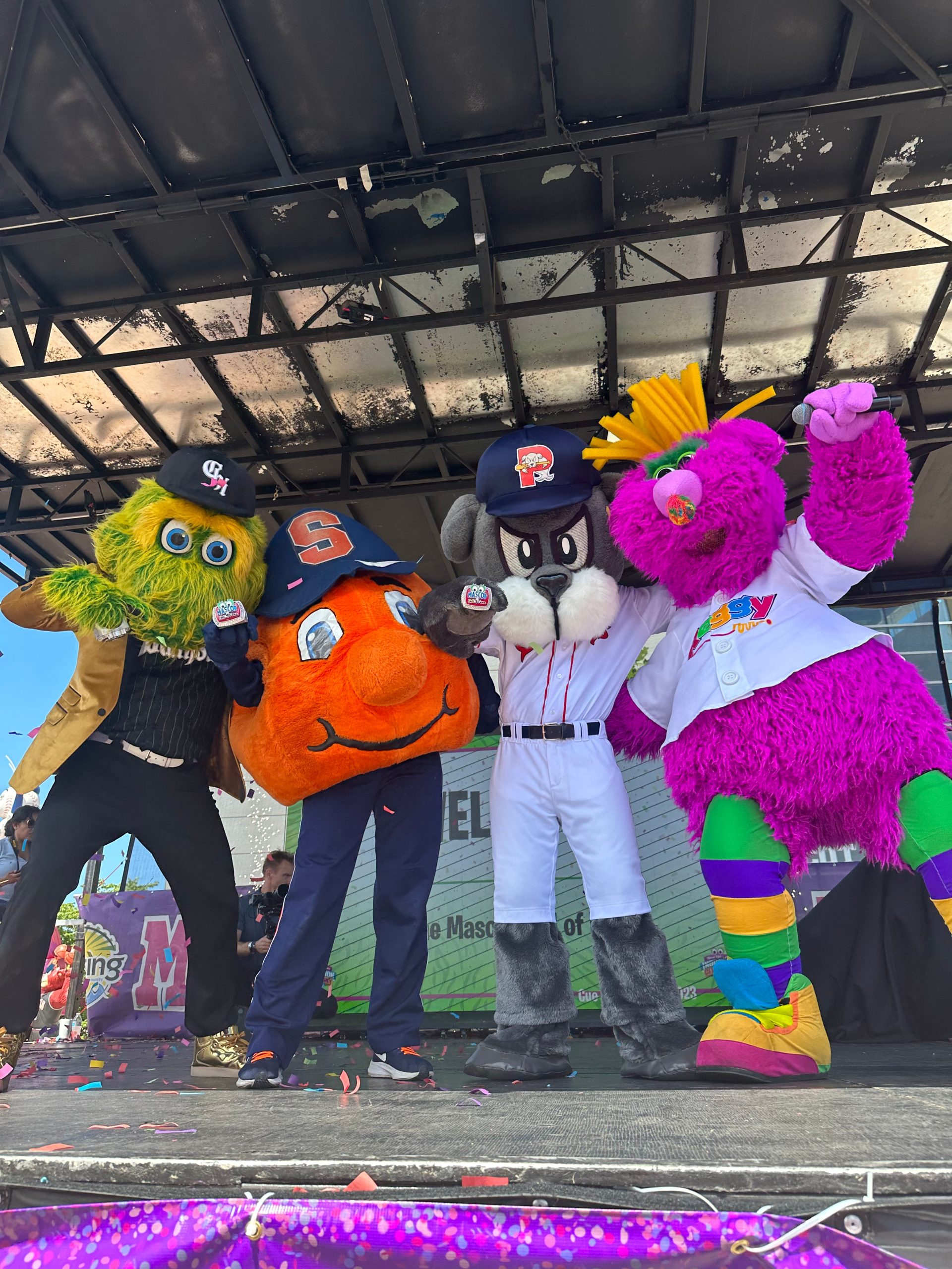Four mascots standing together on stage. 
