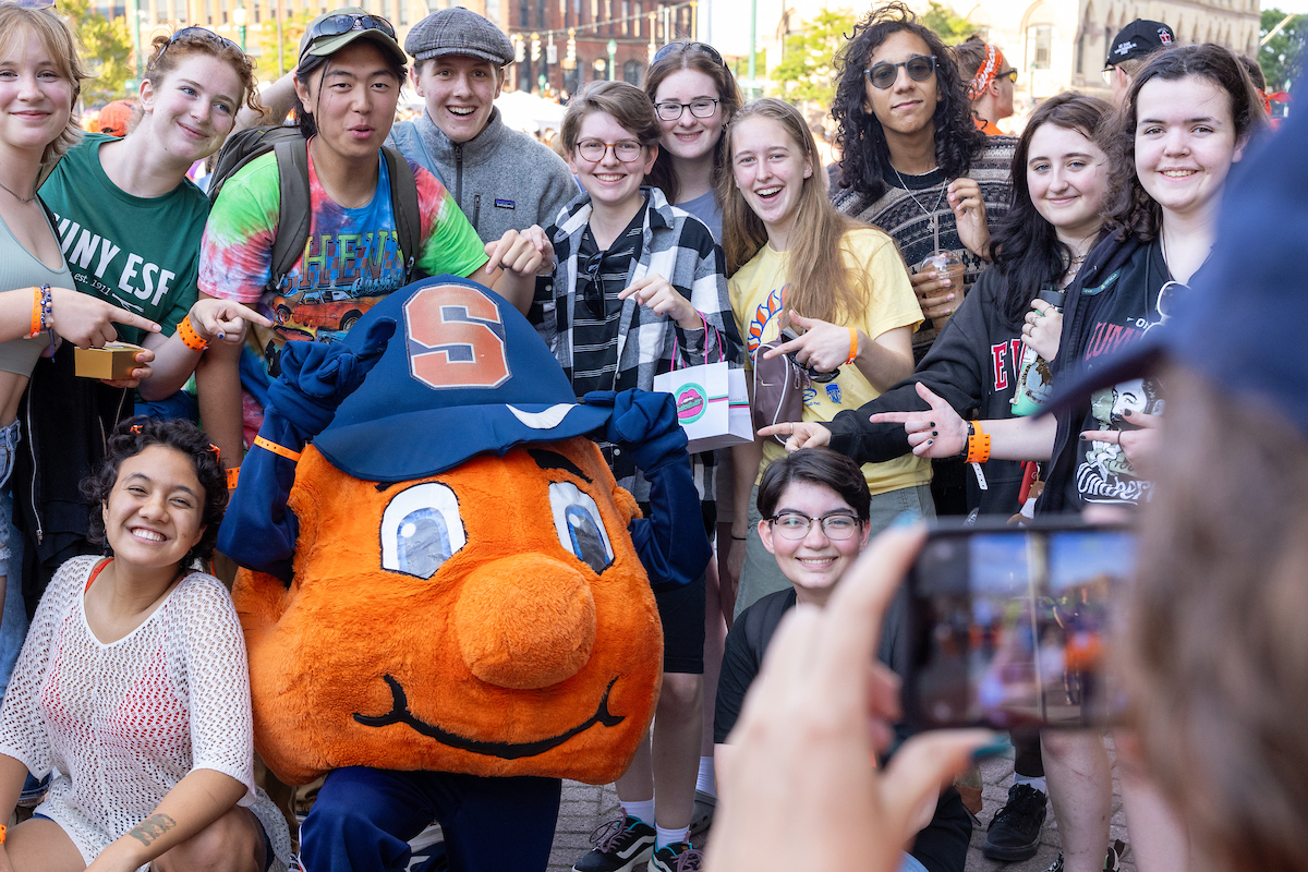 Students pose together for a photo with Otto at Citrus in the City during Syracuse Welcome