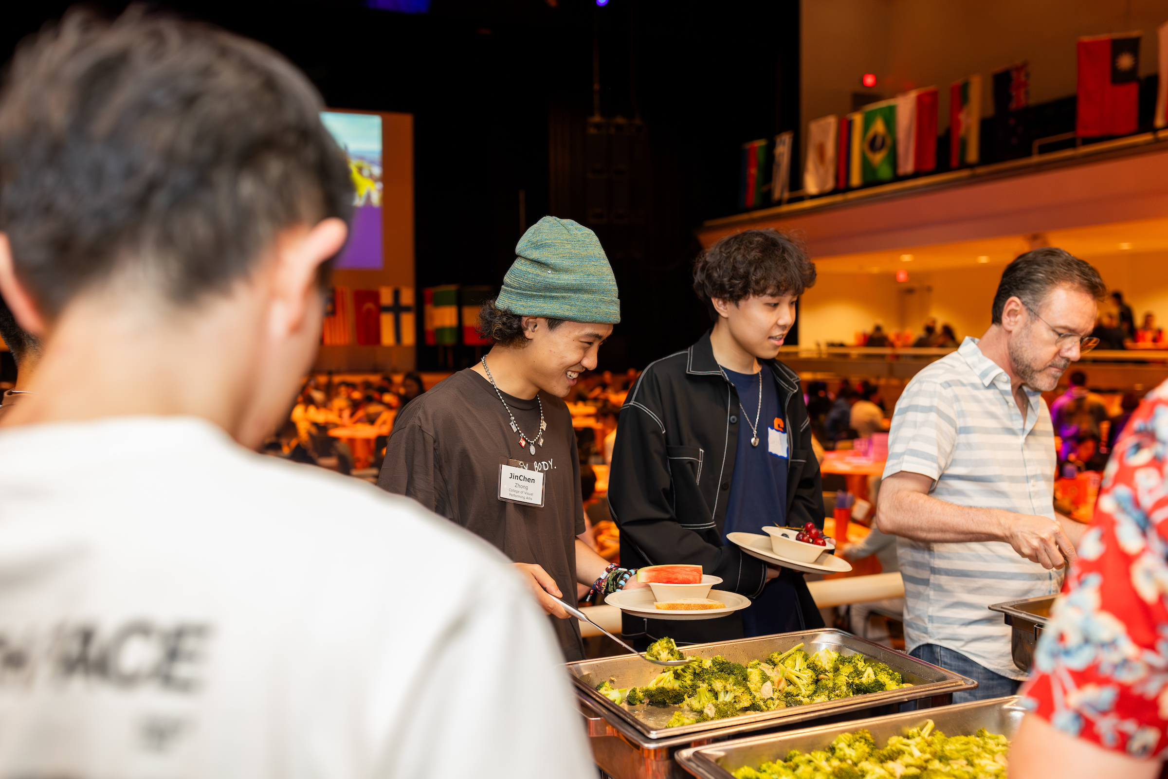 Several students standing in a buffet line getting food.