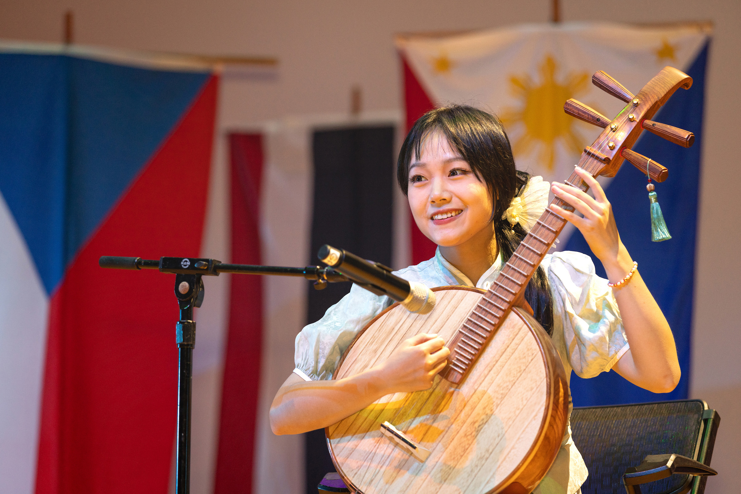 Student playing a musical instrument on a stage.