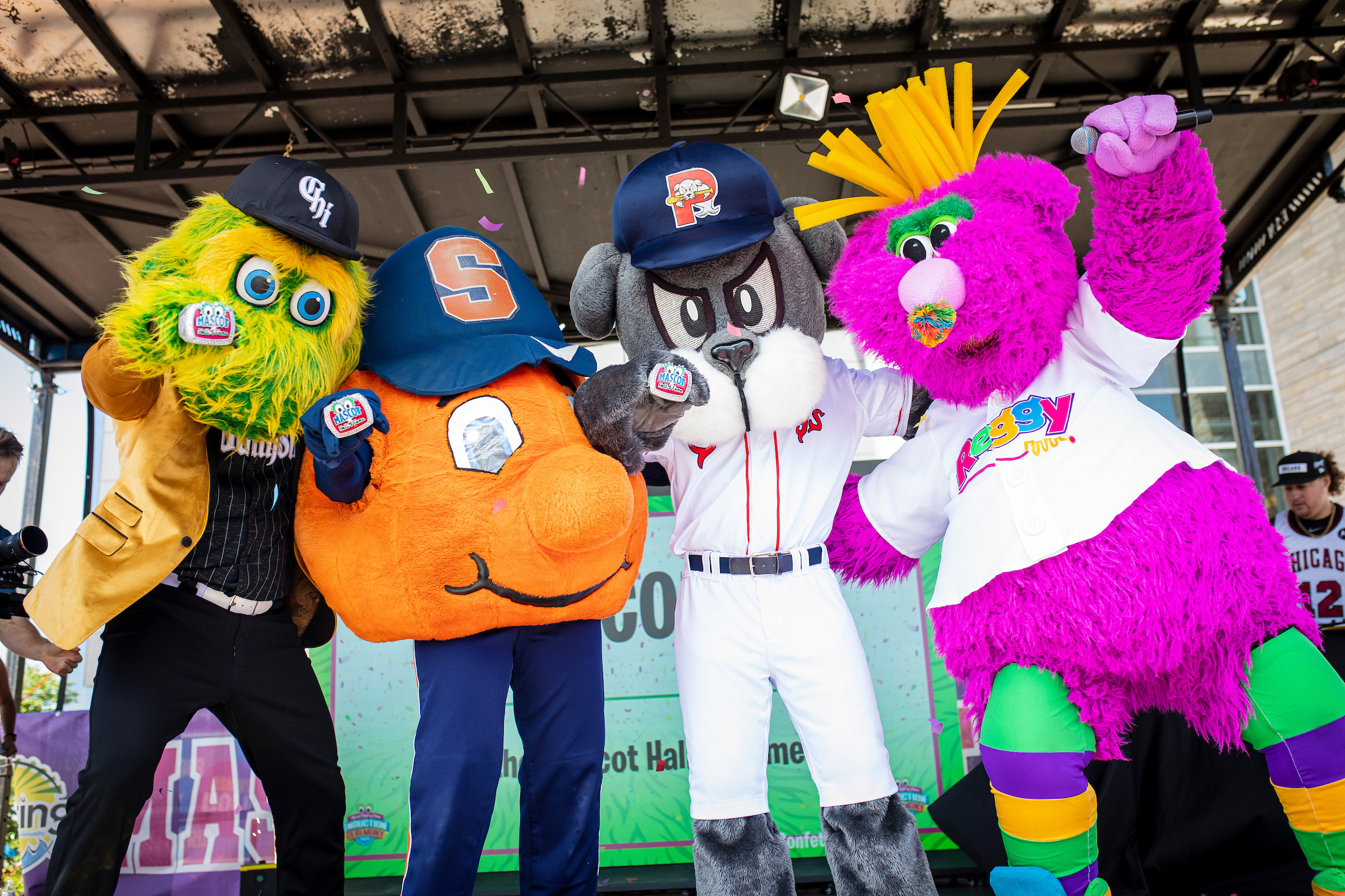Four mascots standing together on stage. 