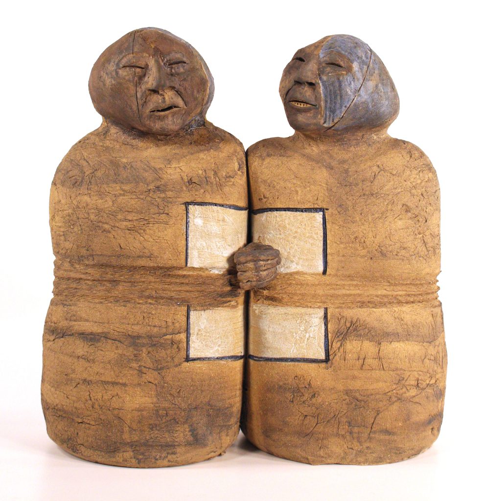 Two clay figures appearing to hold hands