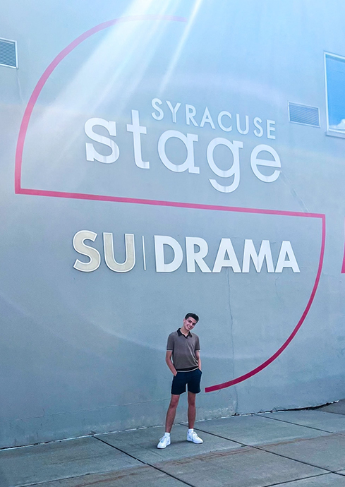 Individual standing in front of the Syracuse Stage SU Drama building
