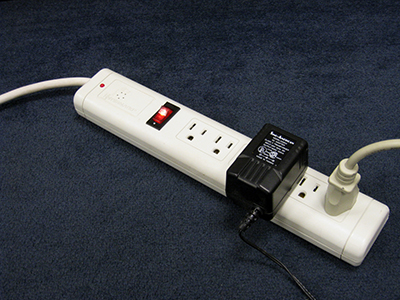 Electrical power strip with with two items plugged in.