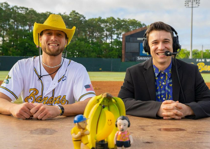 A Savannah Bananas baseball player and a broadcaster pose for a photo at Grayson Stadium.