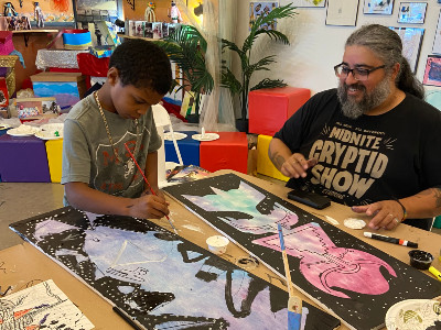 Artist Cayetano Valenzuela working with a young man at La Casita