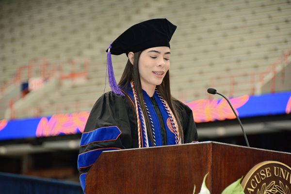 Ludmilla Evelin speaks at a podium at the 2023 College of Law commencement ceremony