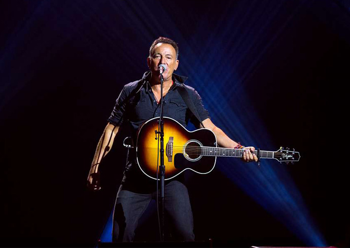 Bruce Springsteen performing on stage with a guitar