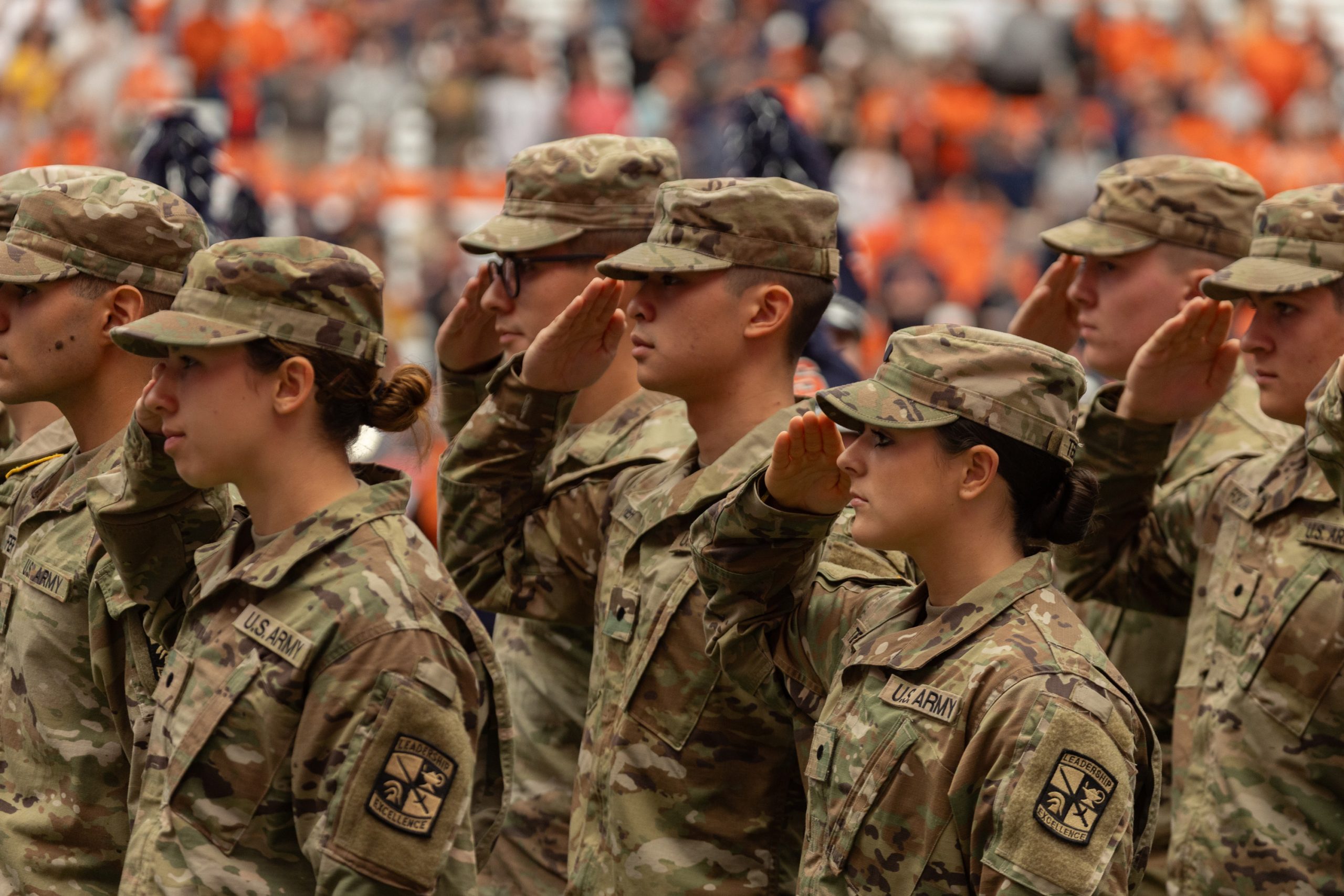 Individuals in military uniforms saluting. 