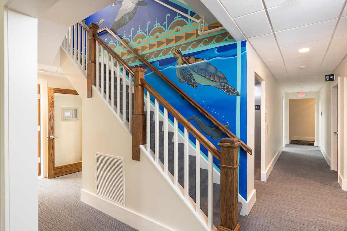 Open stairwell with a mural on the wall with a sea turtle.