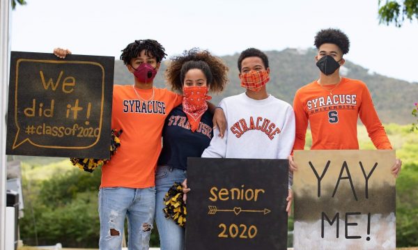 Donovan, Savanna, Dougie and Gabe Capdeville wearing Syracuse gear holding up signs announcing their decision to attend Syracuse in 2020