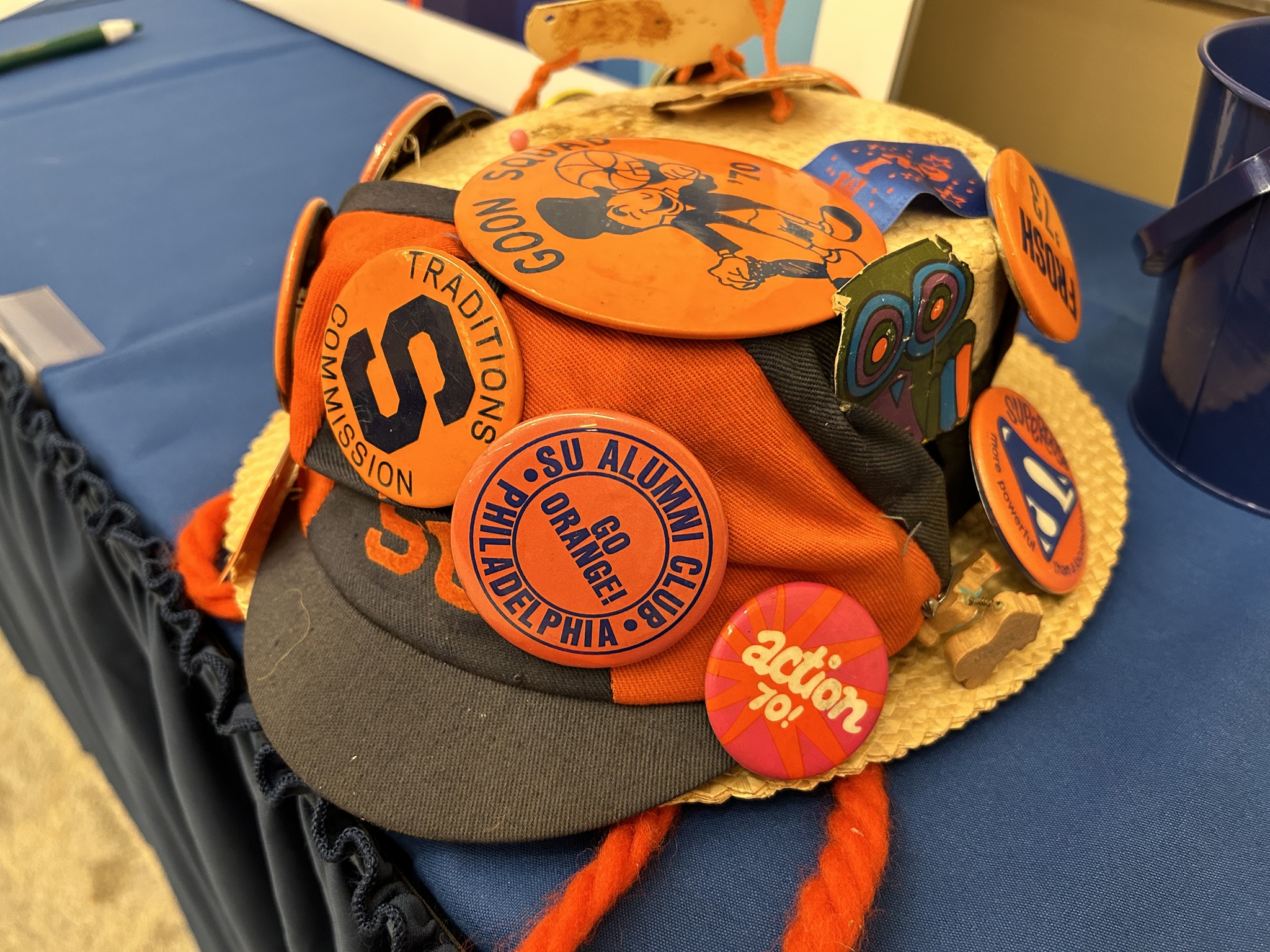 hat filled with orange SU pins