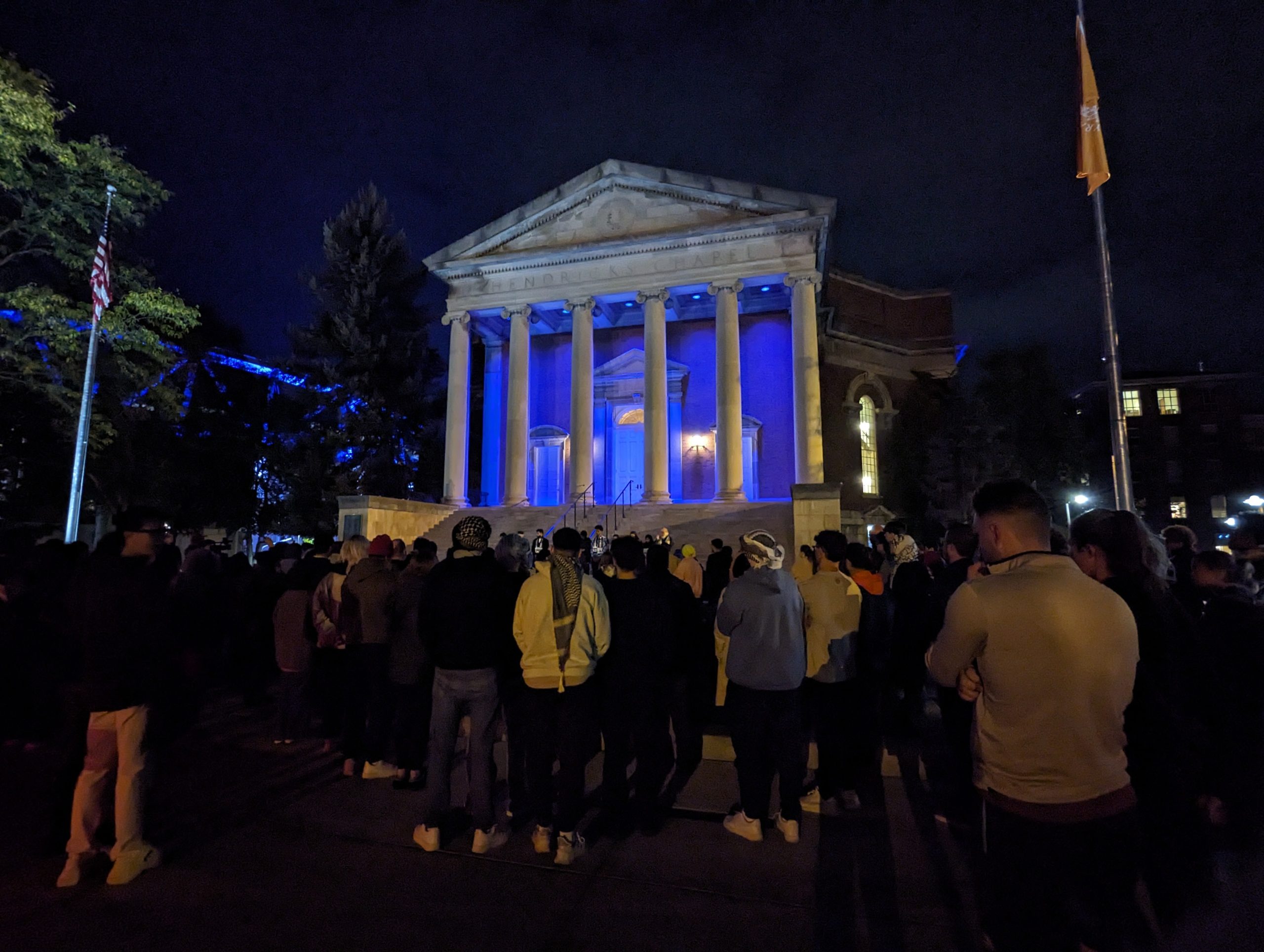 crowd of people in front of Hendricks Chapel at night