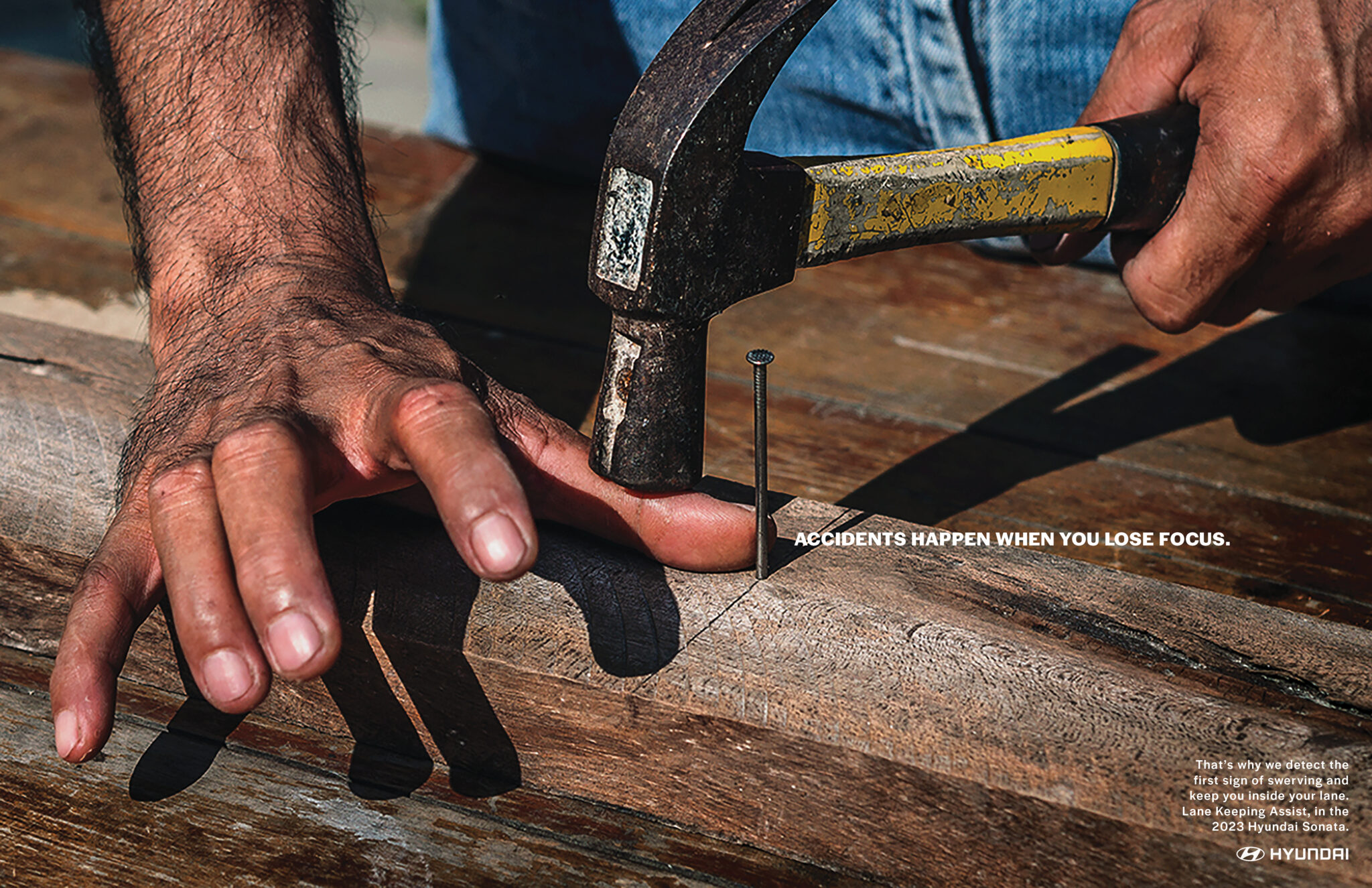 Hyundai car ad that shows a person hitting their thumb with a hammer and the text "Accidents happen when you lose focus"