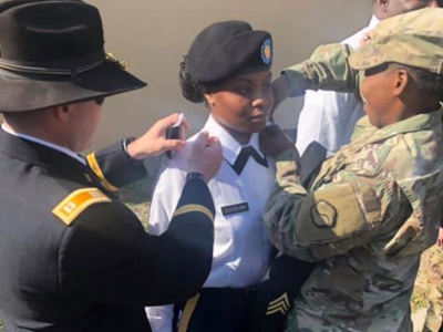 A woman is pinned during a military ceremony.