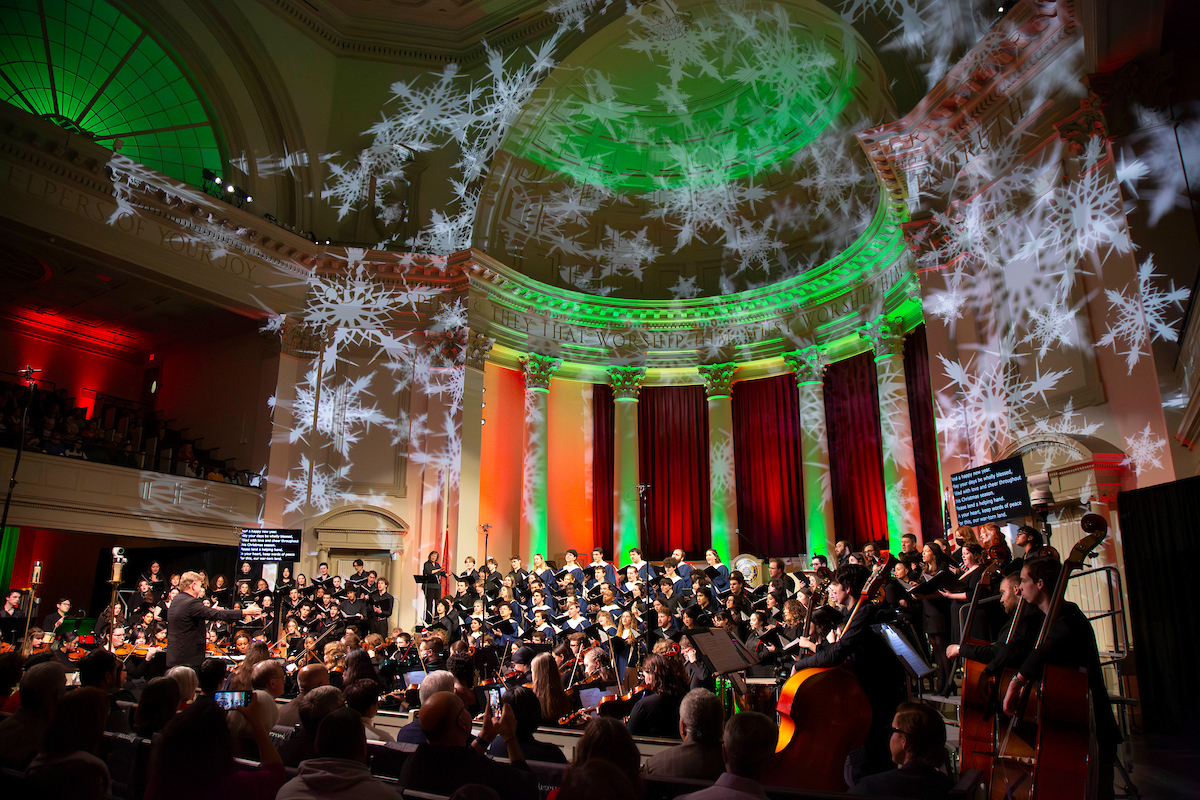 musicians perform in Hendricks Chapel during the annual Holiday at Hendricks event amidst a festive lights display