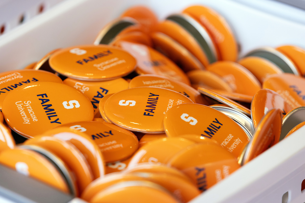 a basket full of orange pins that say "Family" with the Syracuse University Block S and word mark