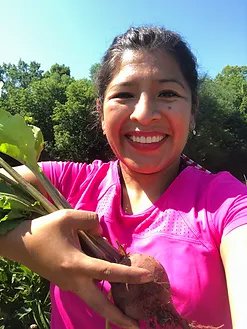 Woman smiling holding vegetable