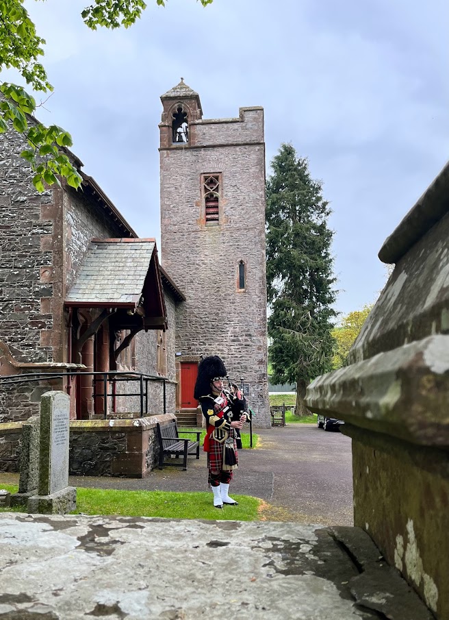 A piper plays outside the Remembrance Room at Tundergarth Church in Lockerbie, Scotland