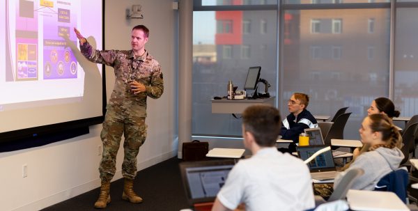 A man teaches a class to current cadets.