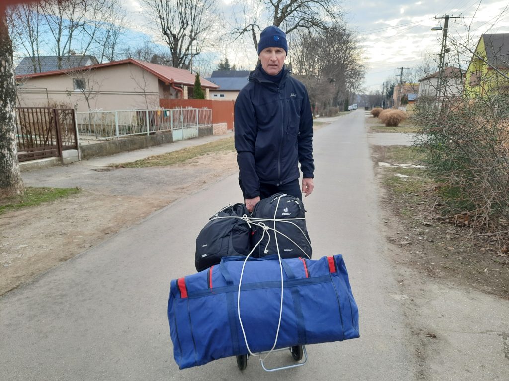 person standing in road with travel baggage