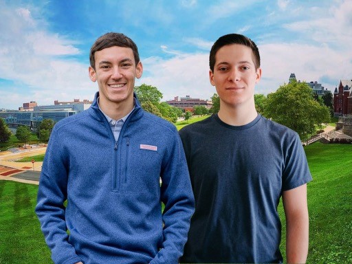 Two men standing next to each other smiling with a campus view in the background.