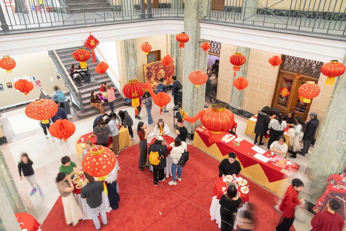 Overhead view of a Lunar New Year celebration with people wandering around a large room that is decorated for the hoiday.