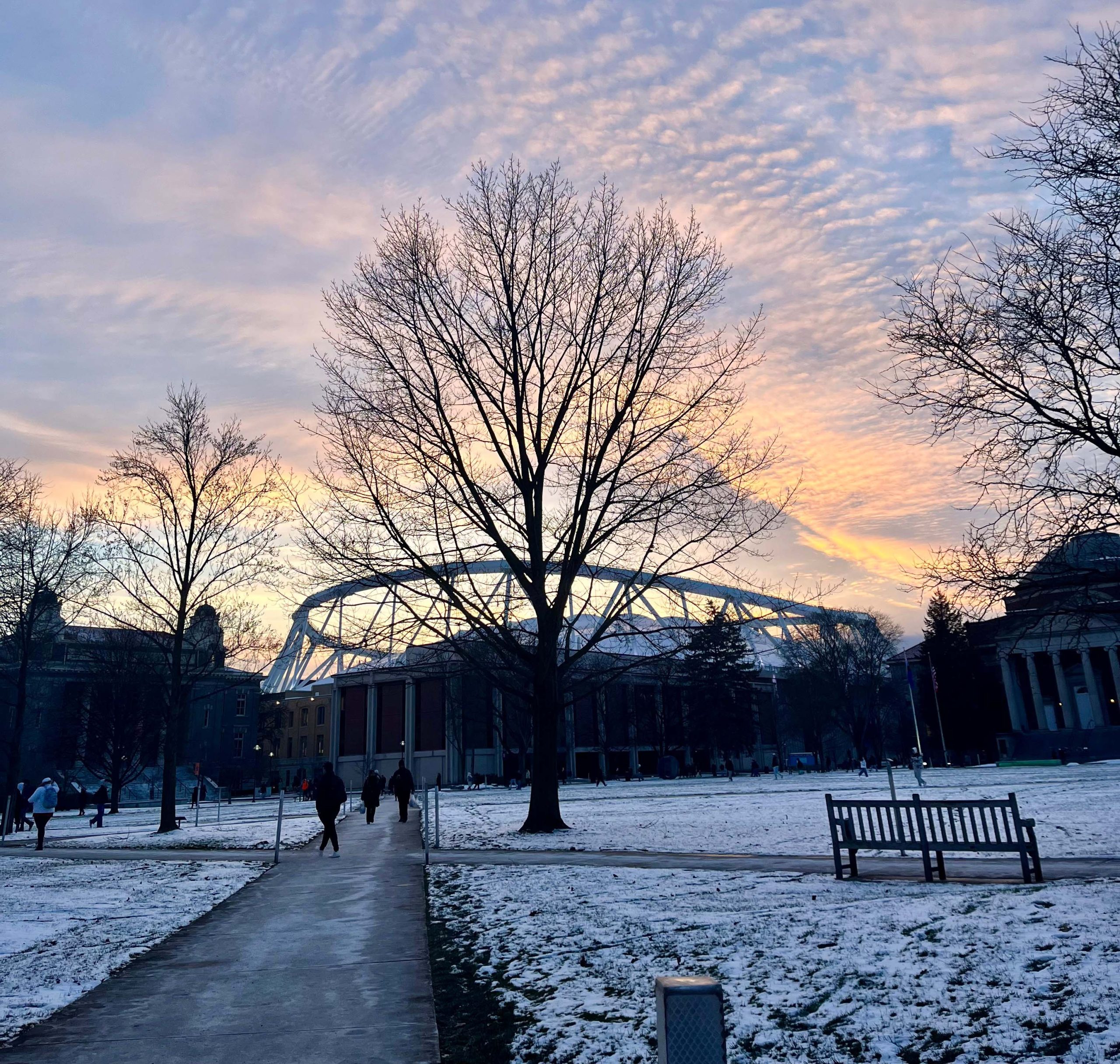 Wintery sunset on the Quad with a snow covered ground at the JMA Wireless Dome in the background.