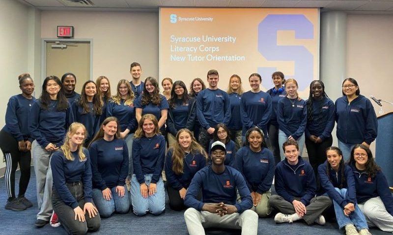 large group of people all dressed in navy blue Syracuse University shirts