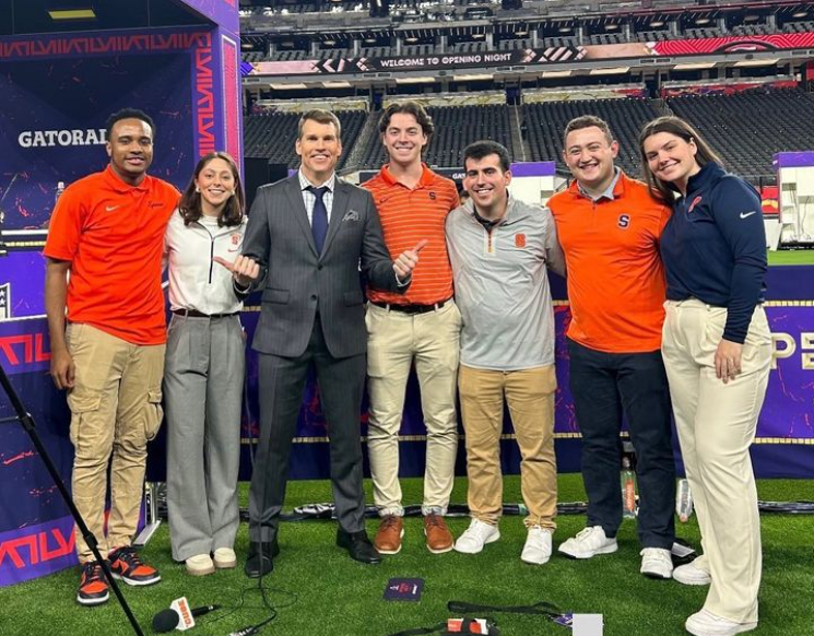 six students post with alumnus Scott Hanson in Allegiant Stadium in the lead-up to the Super Bowl