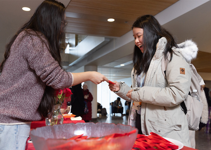 a student receives a red envelope at a Lunar New Year celebration on campus