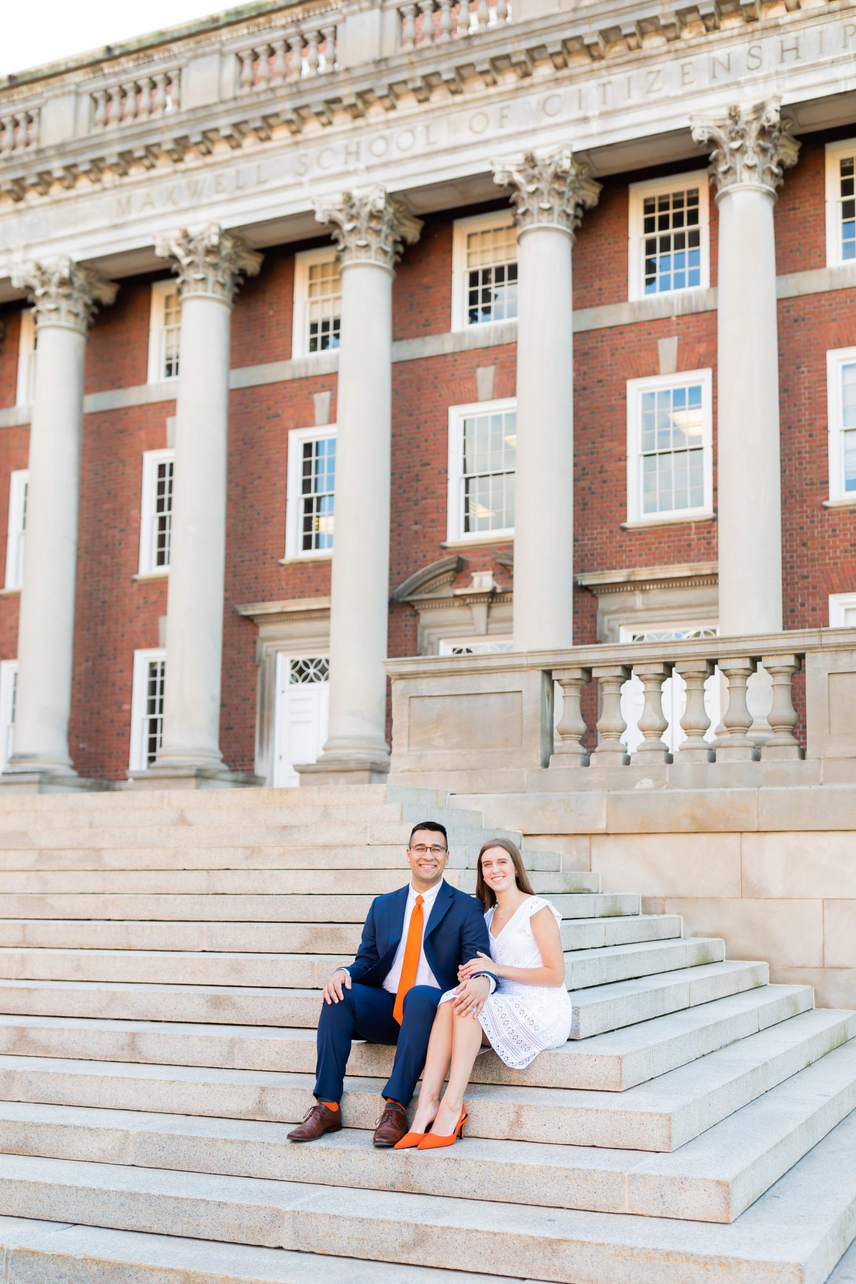 Two people sitting together on the steps in front of Maxwell