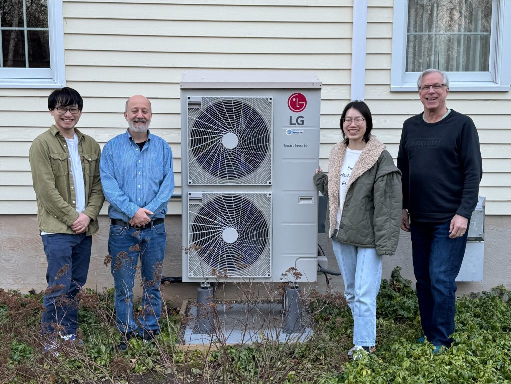four people standing with a heat pump