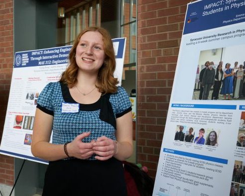 young person presenting information at a poster at a poster session