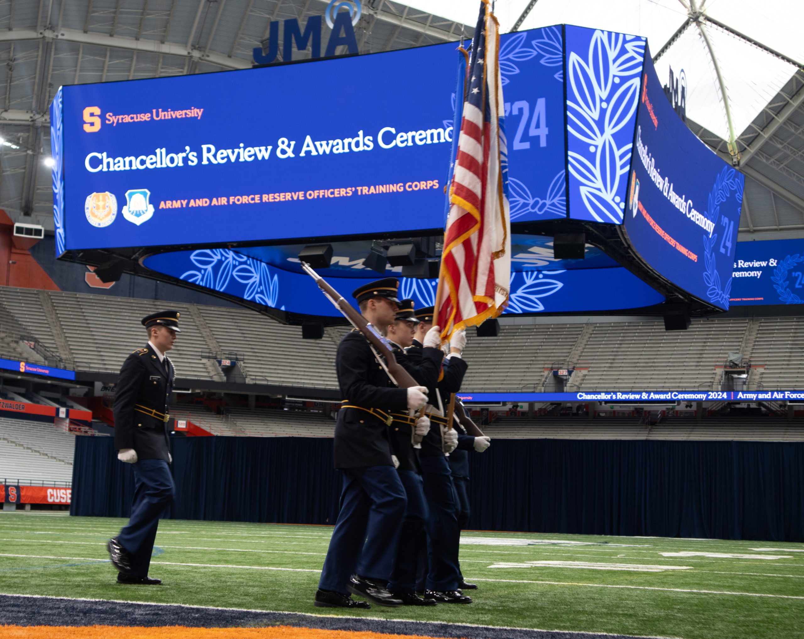 U.S. Army and U.S. Air Force ROTC Color Guard marching across the field in the Dome.