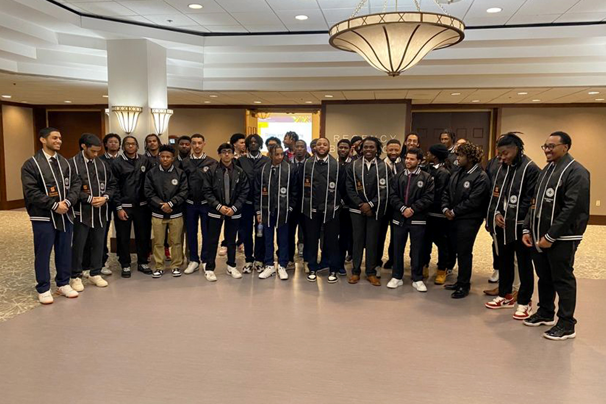 A group of Black students celebrate after the Men of Color's annual Induction Ceremony.