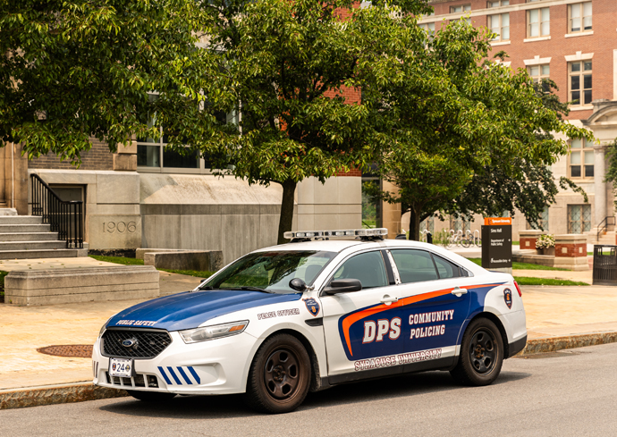 A Department of Public Safety car is parked on campus.