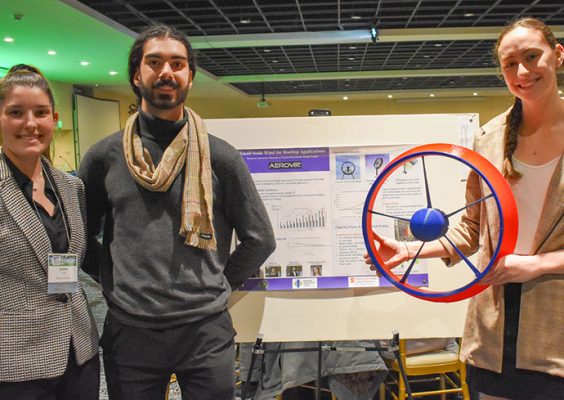 Three students pose in front of their award-winning poster, “Generating Renewable Electrical Energy."