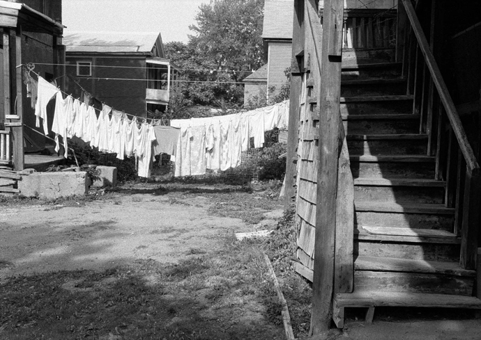 Clothes hang out to dry on a line. A set of stairs is on the right.