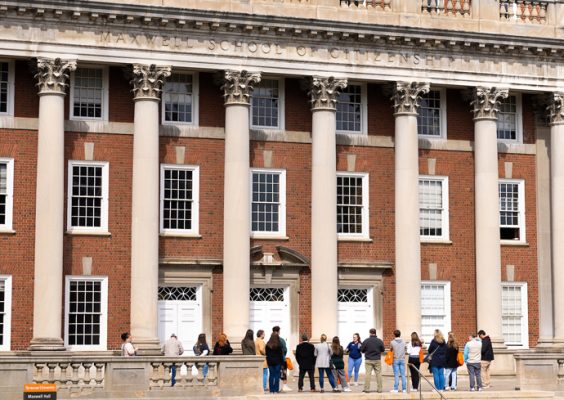 The exterior of the Maxwell School with students attending a tour.