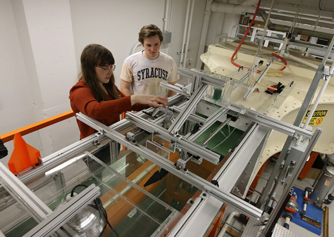 A student works with a professor in the water channel lab.